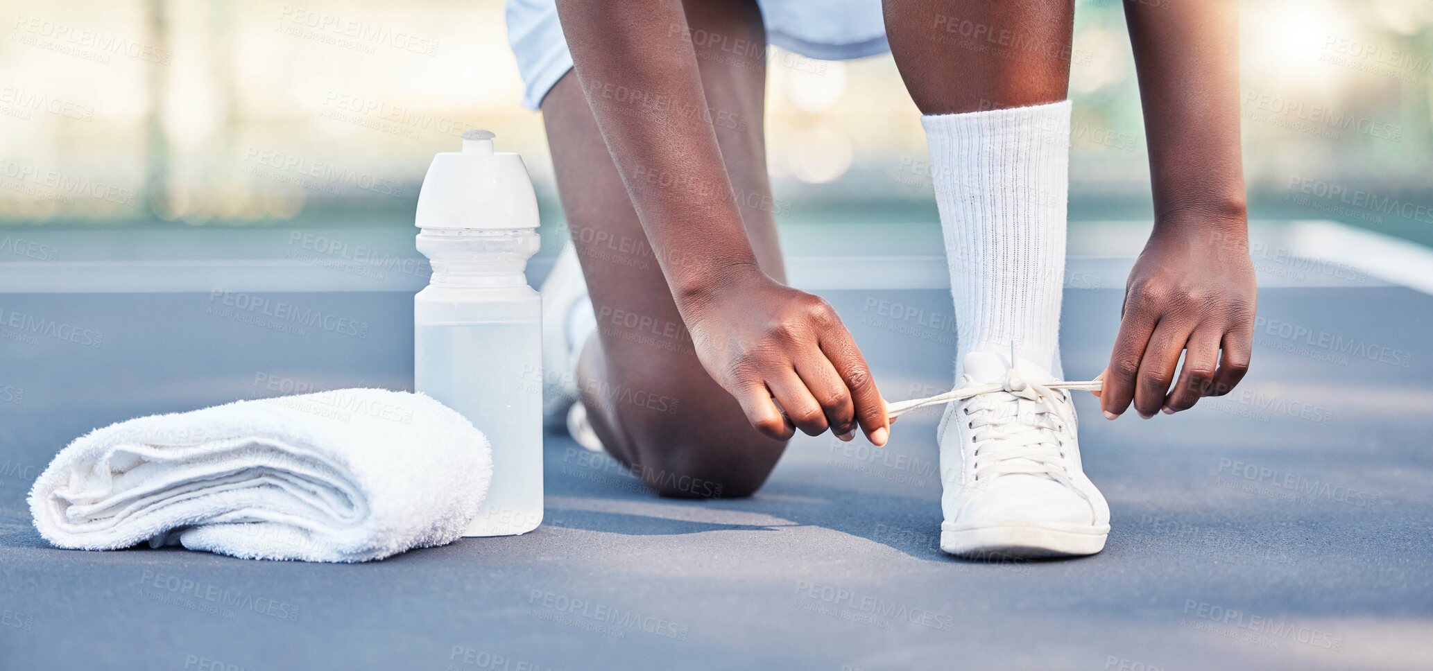 Buy stock photo Tennis, athlete and sports feet tying her shoe laces ready for game, competition or training outdoor with water bottle gear. Fitness sneakers of black woman foot on ground zoom in workout motivation