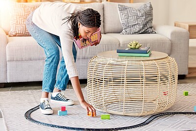 Buy stock photo Spring cleaning, living room and kid toys cleaning of a mother of maid in a home. House worker, mom and clean service with a black woman in a lounge picking op children toy train on the floor carpet
