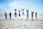 Big family, beach jump and adventure for holiday, sky and bonding for interracial diversity by waves. Happy family, mom and jumping with hands in air for solidarity, care or love on vacation by sea