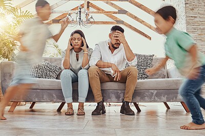 Buy stock photo Tired parents, kids running and family in a living room feeling anxiety, headache and stress. Children chaos, run and fatigue of mom and father together on a couch frustrated from parent care 
