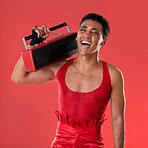 Happy, man and boombox radio in studio for gay, pride and vogue aesthetic with retro 80s tech by red background. Lgbtq model, vintage fashion and music with happiness, listening and comic laughing