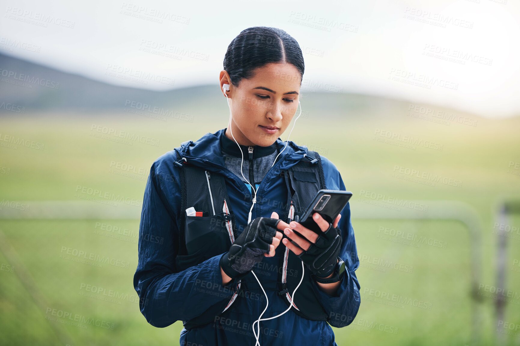 Buy stock photo Music, phone check and woman in the countryside ready for fitness and exercise. Sports, training and mobile headphones of a female athlete looking at gps with audio and web radio for workout