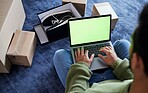 Ecommerce, man with laptop, green screen and boxes on floor, shoes and delivery service on digital app. Sale, discount and online shopping on fashion retail brand website, internet search on computer