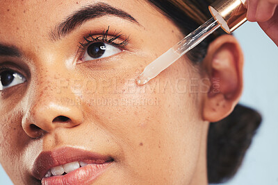 Buy stock photo Woman, face oil and serum in studio for beauty of aesthetic skincare, dermatology and makeup on blue background. Closeup of model with dropper for facial cosmetics, hyaluronic acid and clean shine 