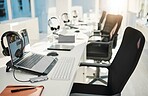 Empty office, call center and headphones with laptop, chair and furniture for telemarketing with voip tech. Help desk, computer and customer service with contact us, technical support or consulting