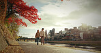 Japanese woman, walking and canal in city by autumn leaves and happiness for bonding in nature. Friends, smile and together in wellness by red maple tree, care and blue sky in tokyo town for sunlight