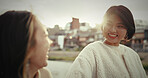 Japanese woman, walking and happy in city by water canal and happiness for bonding in town. Friends, smile and together in wellness by suburban neighborhood, care and lens flare in tokyo for sunlight