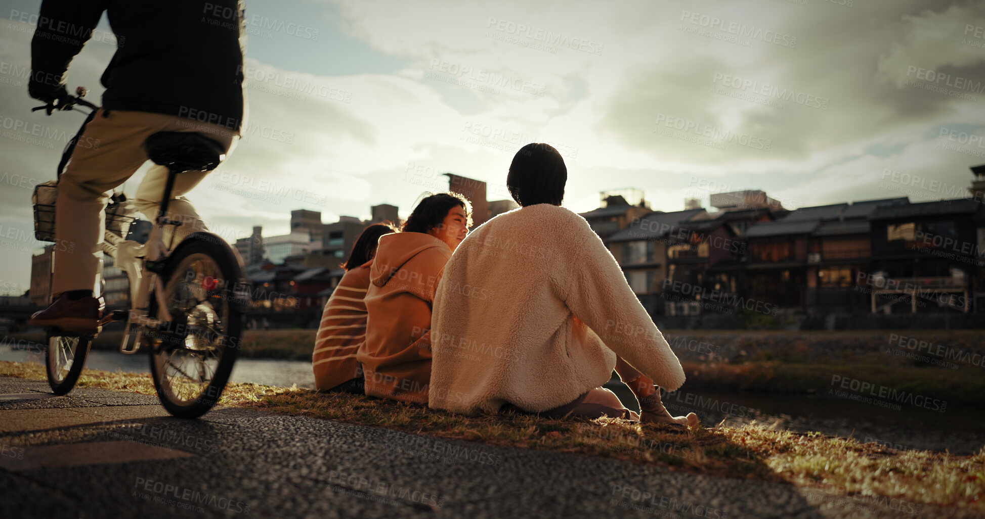 Buy stock photo Friends, sitting and talking in city outdoor with travel, gen z and happy discussion together in japan. People, bonding and back in tokyo town on vacation and holiday with wellness by water canal