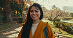 Japanese, portrait and happy woman in park for travel on vacation, adventure and explore path with trees. Gen z, student and smile on holiday walk in autumn nature, forest and trail in Kyoto woods