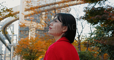 Buy stock photo Thinking, outdoor and Japanese woman in city for travel by train in autumn with trees and happiness. Park, nature and business person in Tokyo to commute in morning on subway metro transportation