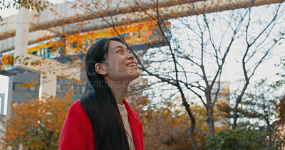 Buy stock photo Japanese woman, thinking and outdoor in city for travel by train in autumn with trees and happiness. Park, nature and person in Tokyo forest on commute in morning on subway metro transportation