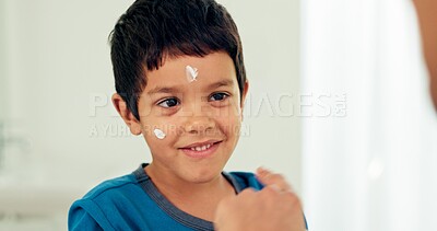 Young boy, skincare and lotion with a smile from morning hygiene and cream. Laugh, kid and moisturizer with youth in a family home and bathroom with sunscreen and facial care and clean cosmetics