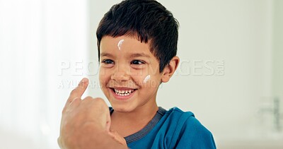 Young boy, skincare laugh and lotion with a smile from morning hygiene and cream. Laugh, kid and moisturizer with youth in a family home and bathroom with sunscreen and facial care and cosmetics