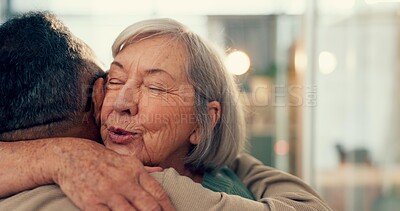 Love, hug and an elderly couple in their home together for support, trust or care during retirement. Diversity, smile or happy with a senior woman and man embracing for romance in their house