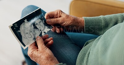 Photograph, hands and memory of a person on a home sofa for nostalgia, history and to remember. Senior adult with pictures and thinking of old album, nostalgia and wedding photography in retirement