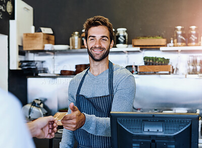Buy stock photo Shot of a handsome young businessman taking payment from a customer