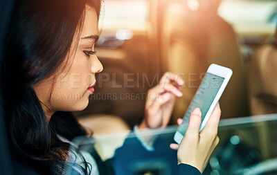 Buy stock photo Shot of an attractive young woman using a cellphone in a car