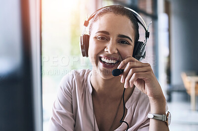 Buy stock photo Portrait of a cheerful businesswoman talking to a customer using a headset while looking at the camera