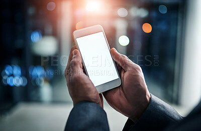 Buy stock photo Businessman hands holding phone with white screen template in modern office. Closeup businessperson reading text message on smartphone at night while working overtime at work