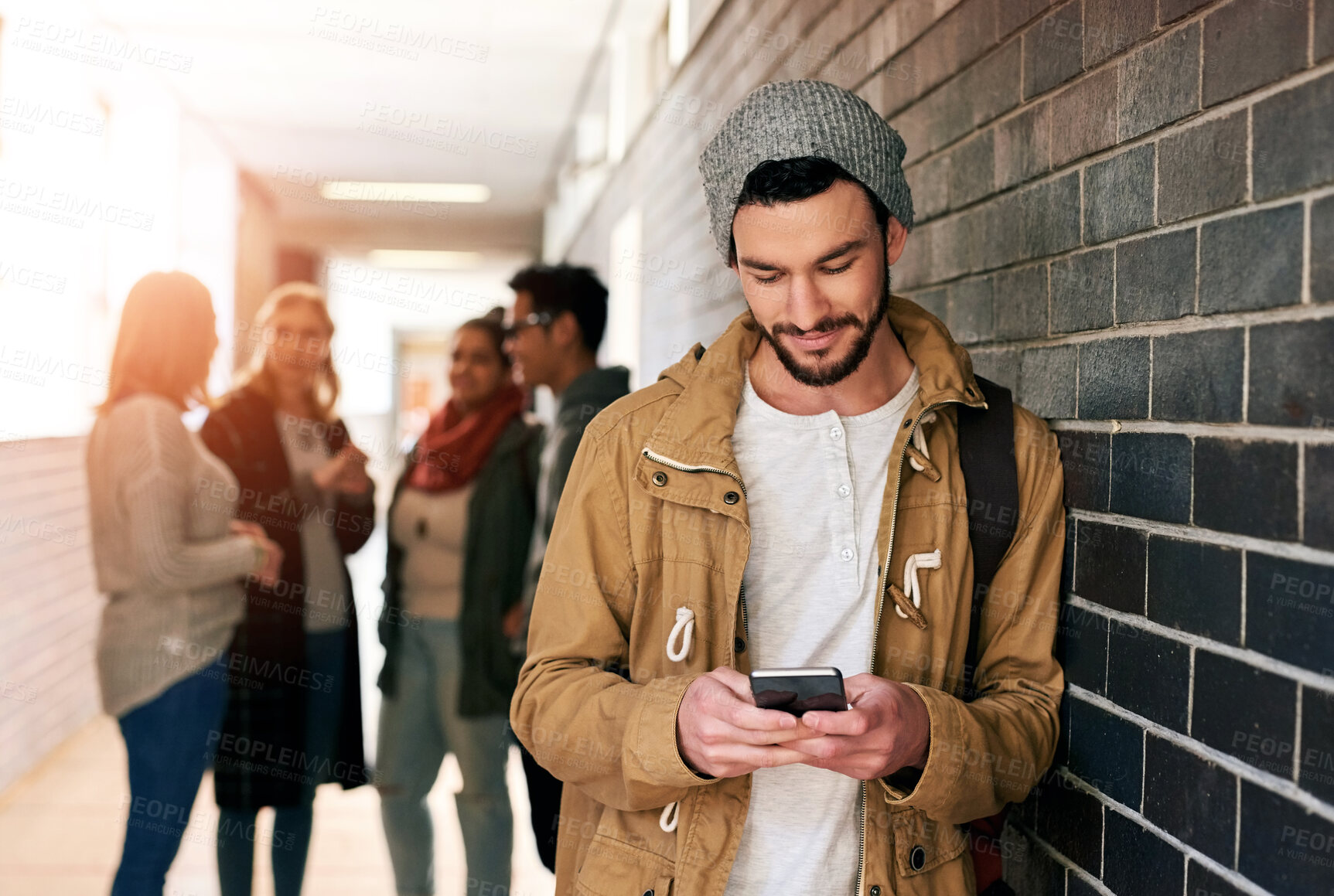 Buy stock photo Hallway, university and man with phone for social media, online class schedule and website on campus. College, school and male student on smartphone for learning, education and academic registration