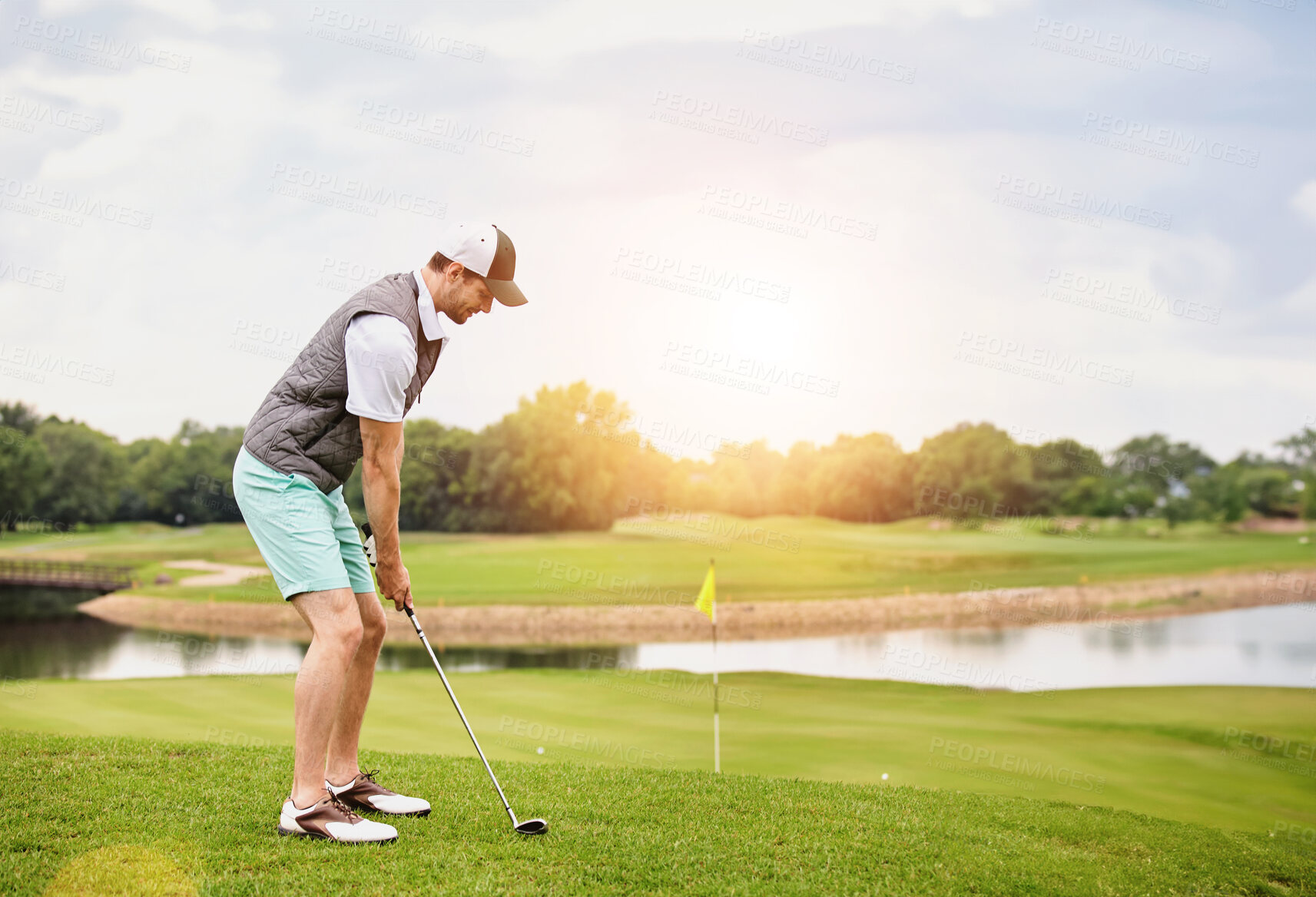 Buy stock photo Hobby, lake and sports with man on golf course to practice for aim, competition or training. Game, grass and green with person hitting ball outdoor in summer for leisure or recreation on holiday