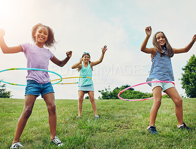 Buy stock photo Shot of a group of young girls playing with hula hoops in the park