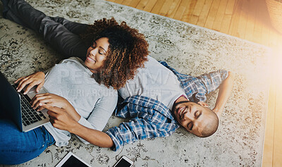 Buy stock photo Happy, relaxed and carefree couple bonding together on the living room floor at home. Loving, affectionate and smiling boyfriend and girlfriend relaxing, typing on a laptop and lying down from above