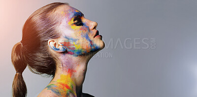 Buy stock photo Studio shot of an attractive young woman with brightly colored makeup against a purple background