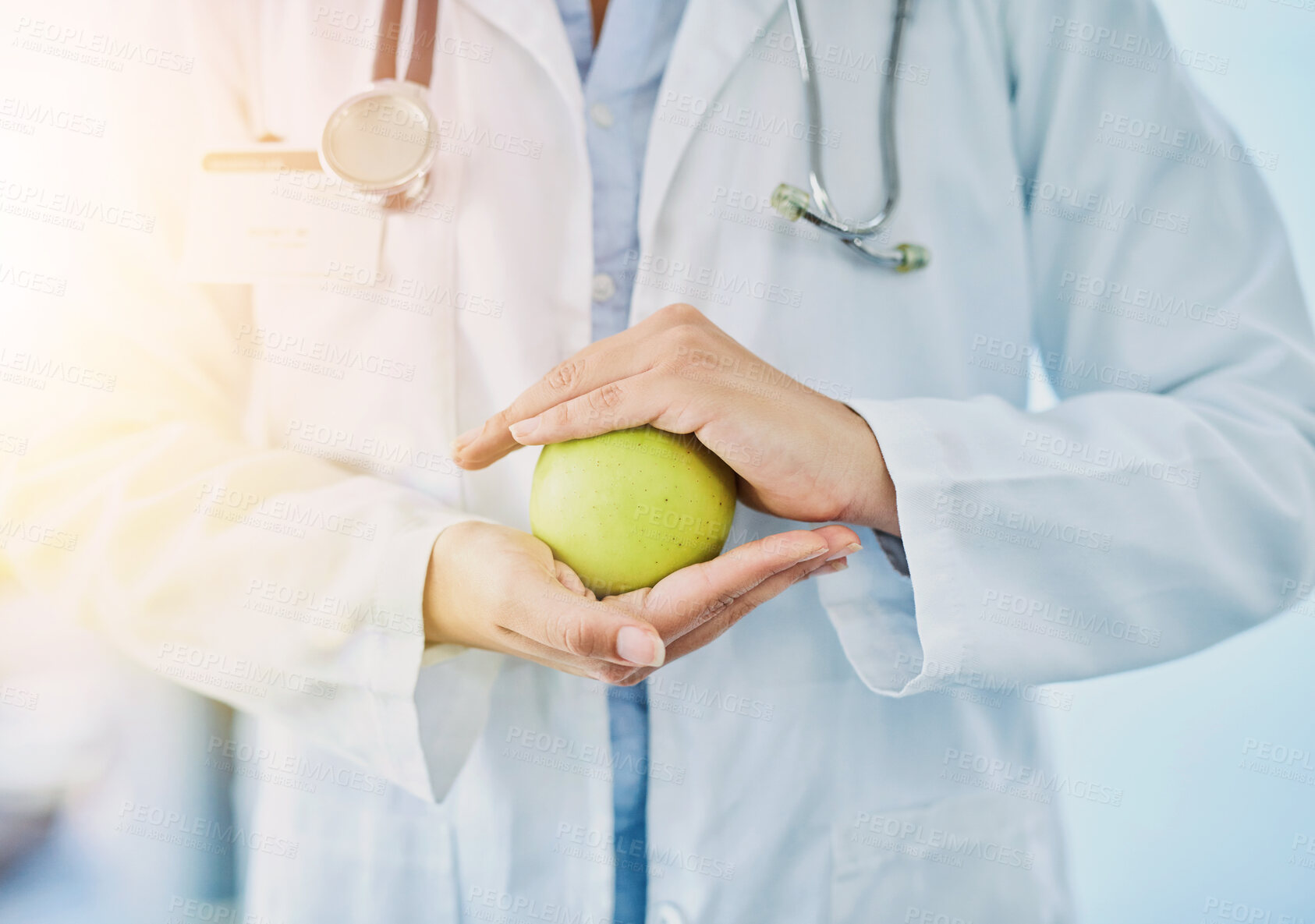 Buy stock photo Apple, hands and healthcare with doctor in hospital closeup for diet, nutrition or wellness. Food, fruit or medical with professional medicine person in clinic for benefits, digestion and vitamins