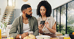 Man, woman and smartphone by table in kitchen for social media, help or assistance of app. Couple, bonding and technology with smile for happy explanation, blog or website at home together