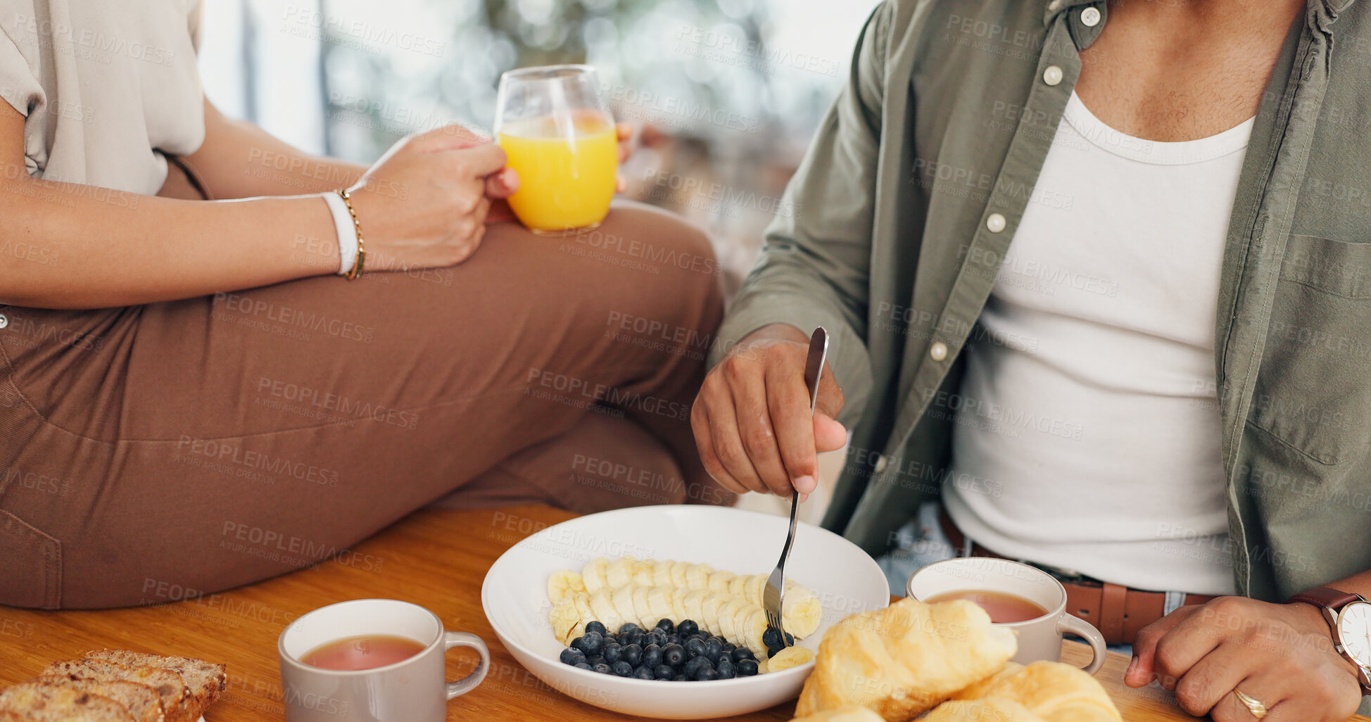 Buy stock photo Health, hands and couple eating breakfast with fruit, coffee and juice at table for wellness diet. Food, wellness and closeup of man and woman enjoying brunch meal together in morning at home.