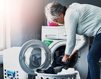 Buy stock photo Shot of a mature woman doing laundry at home