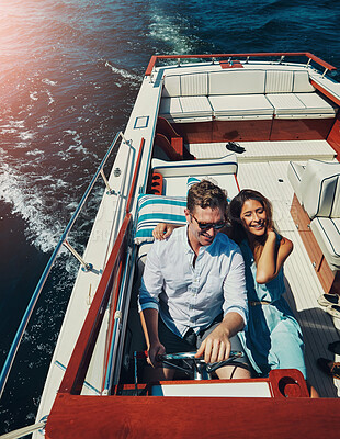 Buy stock photo High angle shot of an affectionate young couple sailing on the open seas in their yacht