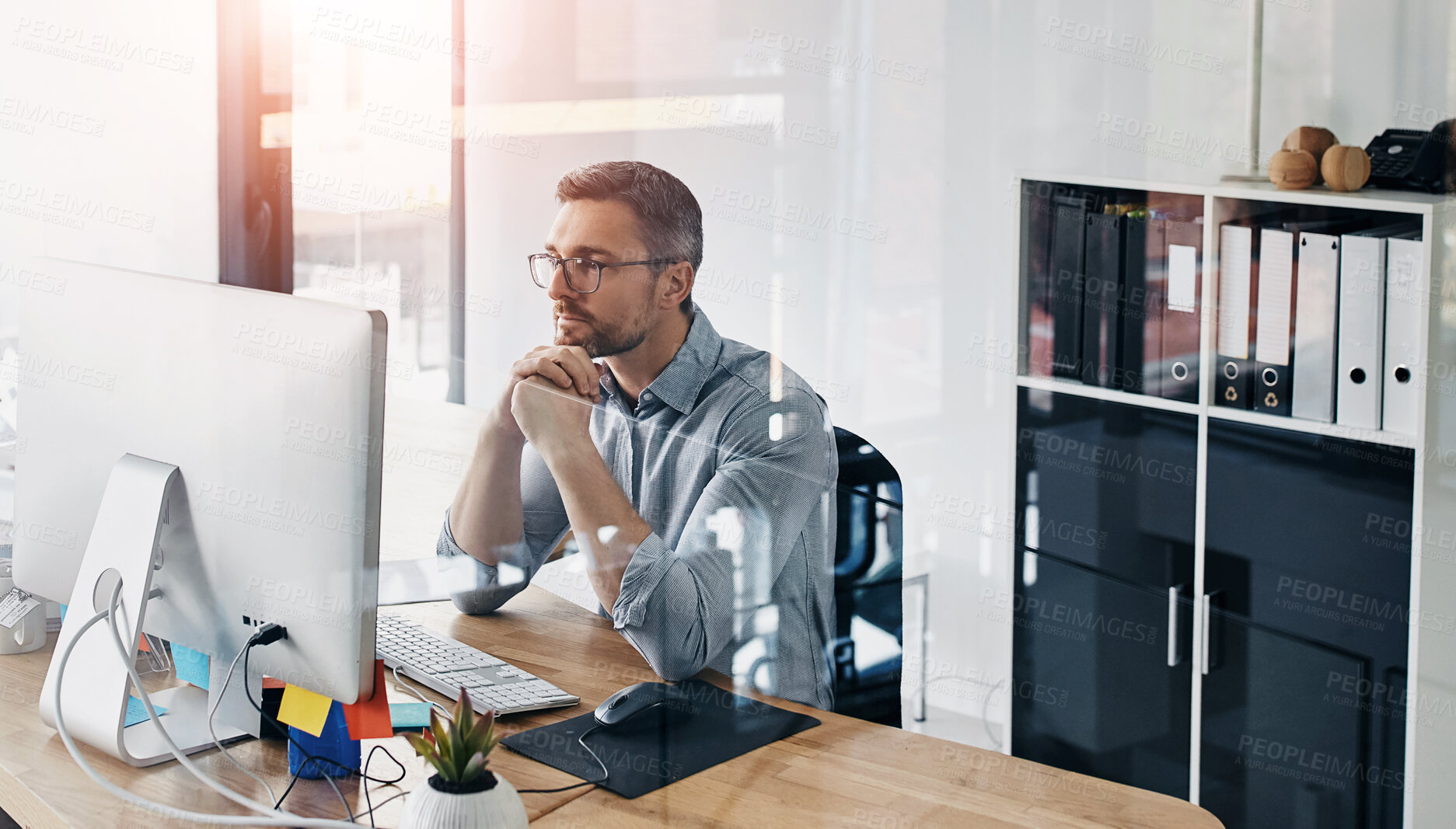 Buy stock photo Cropped shot of a businessman working on his computer at his desk