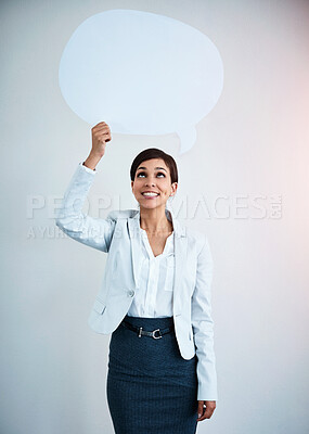 Buy stock photo Studio shot of an attractive corporate businesswoman holding up a speech bubble against a gray background