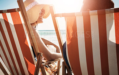 Buy stock photo Happy, travel and couple on beach chair by ocean for bonding, relax together and honeymoon by sea. Dating, love for man and woman with sunshine for romance on holiday, vacation and weekend outdoors