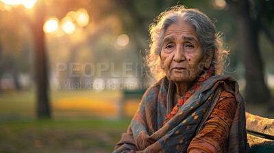 Portrait, elderly Mexican and woman sitting in park. Senior, female and mental health concept. Sadness, longing and thoughtful for mental health and reminiscing with beautiful blurry background.