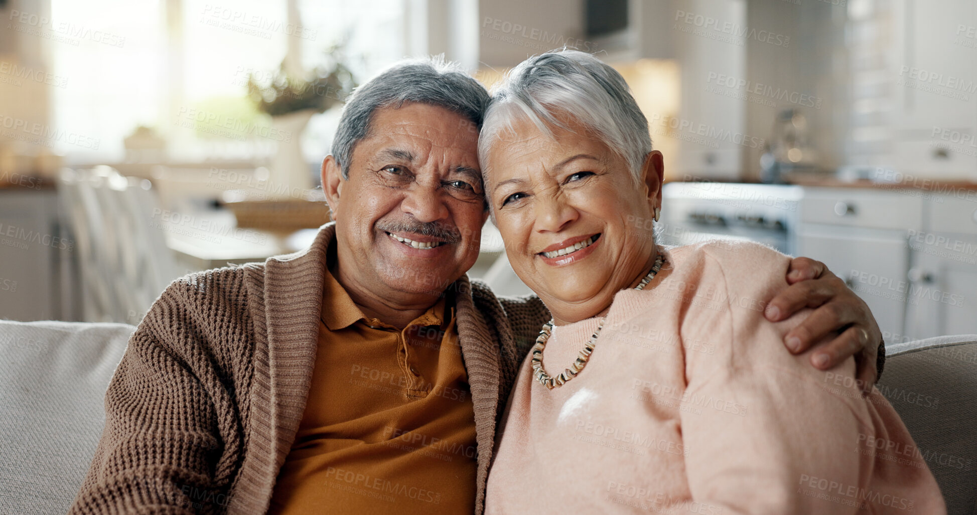 Buy stock photo Senior couple, face and hug on couch, smile and bonding with love, support and relax in retirement in home. Elderly woman, old man and portrait with embrace, together and sitting on living room sofa