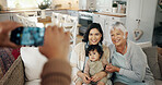 Phone screen, hands and picture of family in living room with smile, kids and grandparent on sofa. Social media, photo and mother with a baby and grandmother happy in a home together with love