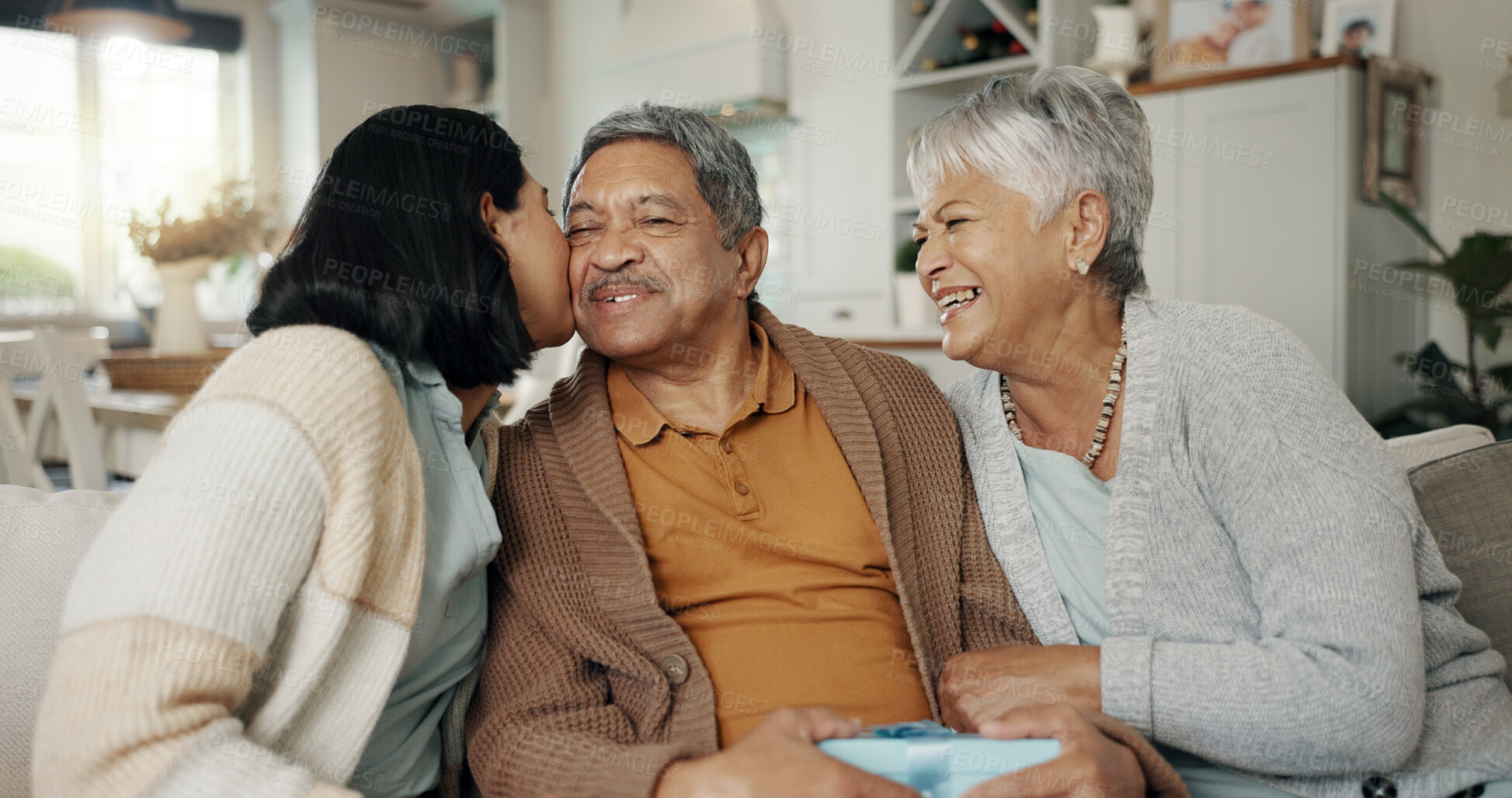 Buy stock photo Birthday, gift and senior parents on sofa for celebration, festive event and bonding together at home. Happy family, party and elderly mother and father with daughter for present, surprise and love