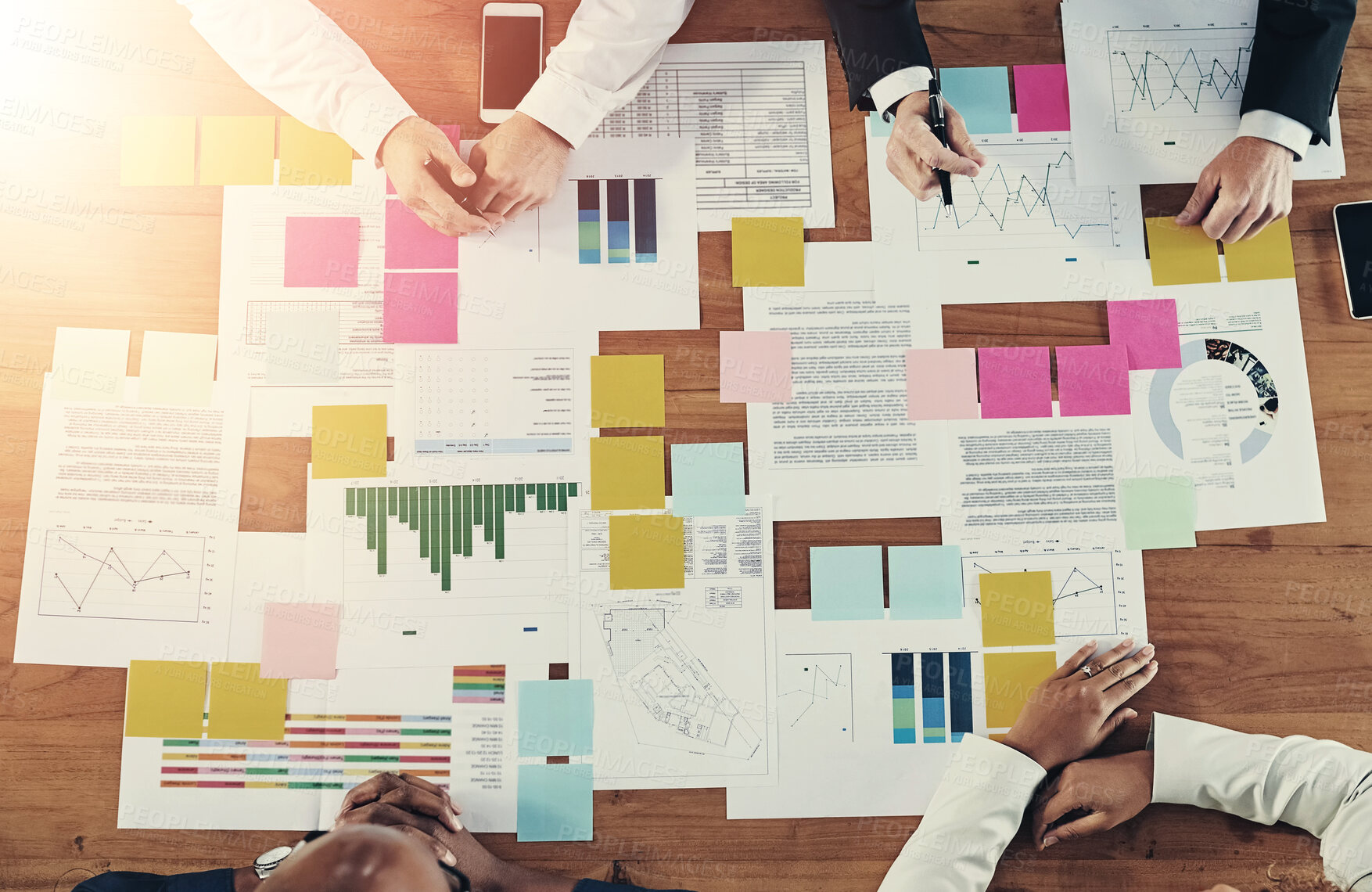 Buy stock photo High angle shot of a group of unrecognizable businesspeople having a meeting in their office