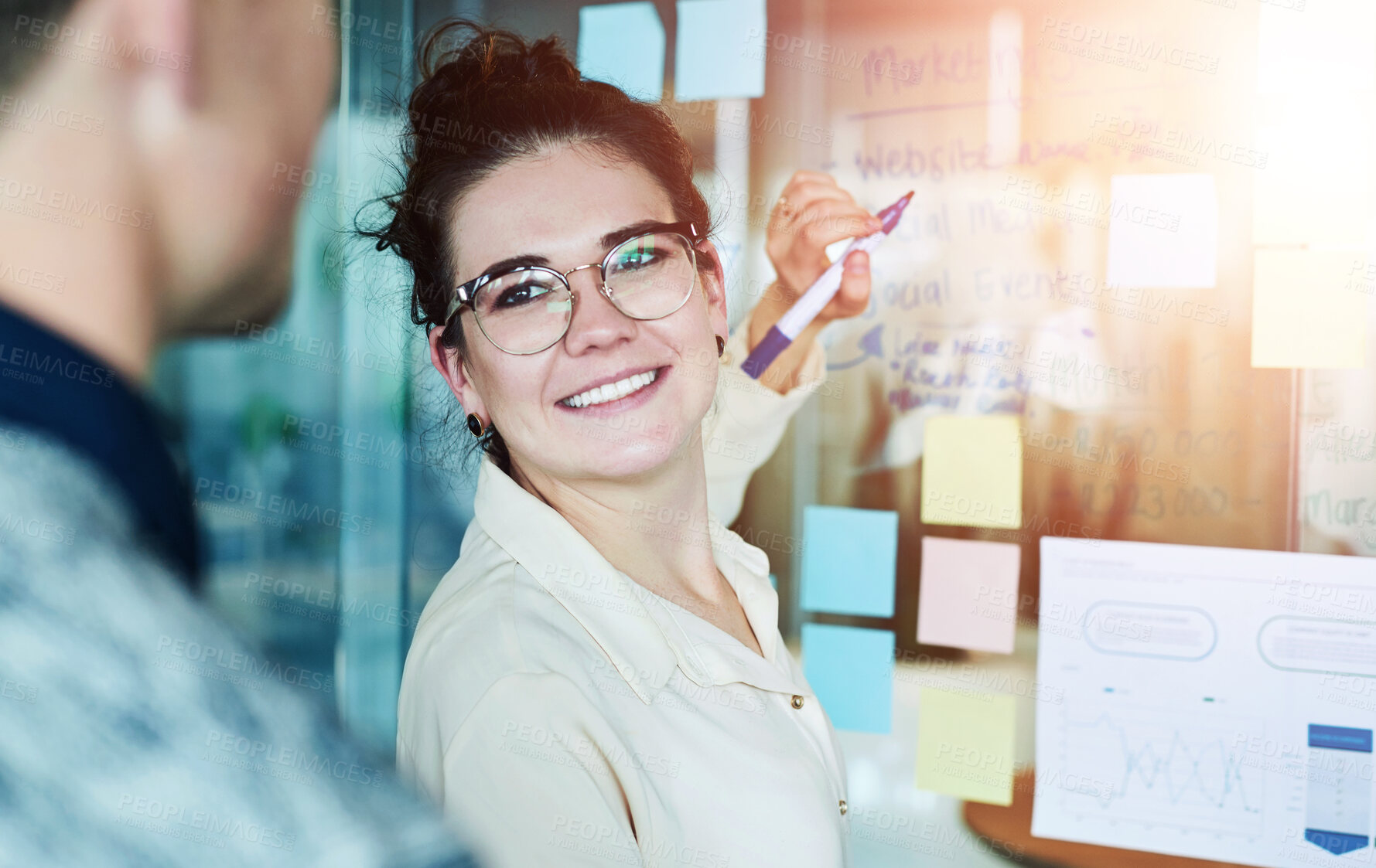 Buy stock photo Shot of a group of businesspeople brainstorming with notes on a glass wall in an office