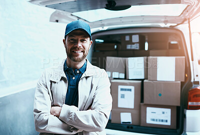 Buy stock photo Portrait of a cheerful young delivery man standing next to a van full of boxes with his arms folded outside during the day