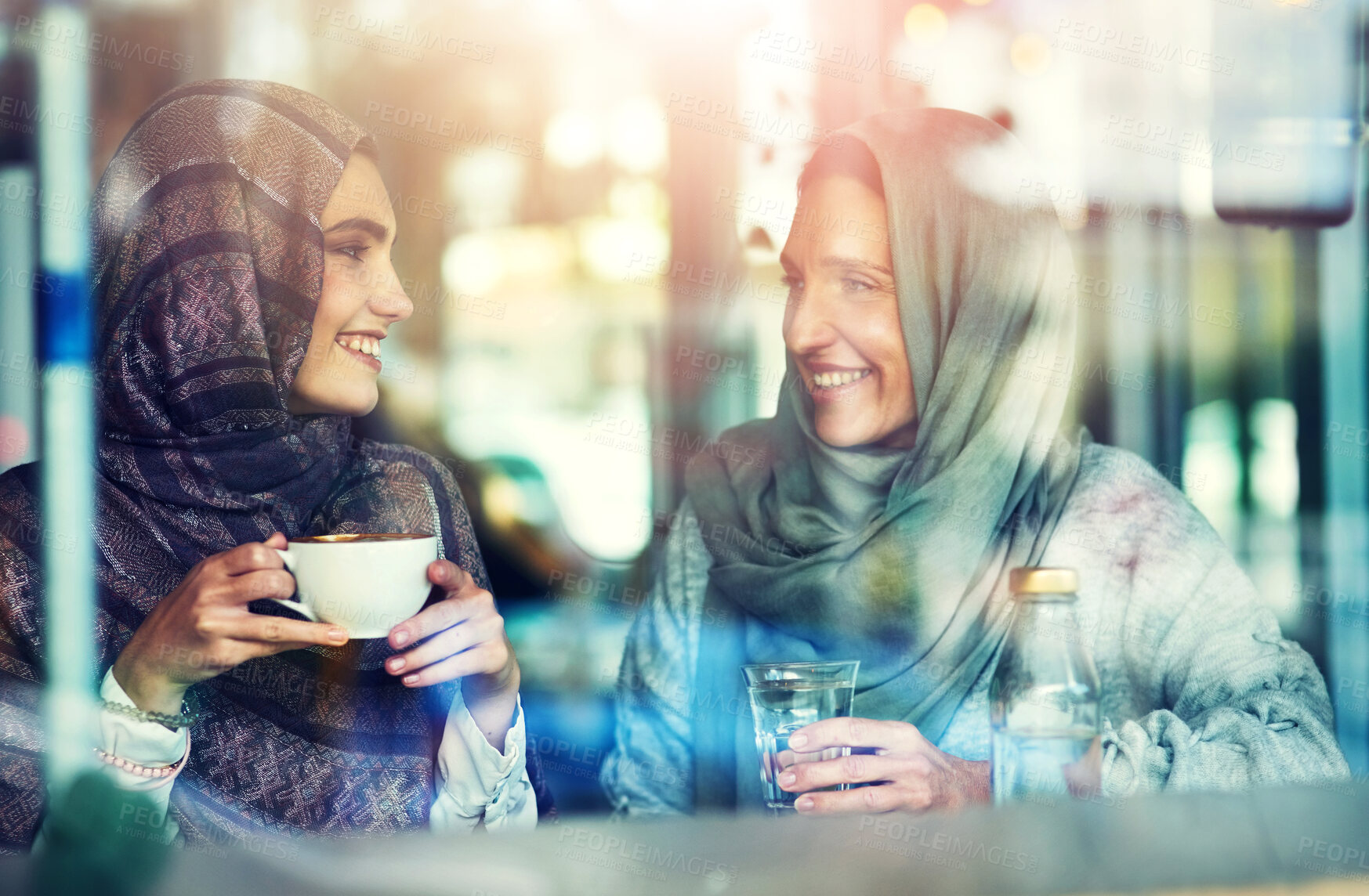 Buy stock photo Talking, friends and muslim women with hijab in cafe for conversation, social date or peaceful lunch break. Relax, happiness and people with coffee for speaking, discussion or catch up in restaurant