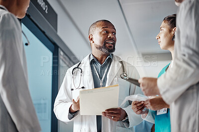 Hospital, teamwork and doctor with folder, conversation and brainstorming for healthcare and administration. Medical, leader and senior professional with group and meeting with documents and clinic