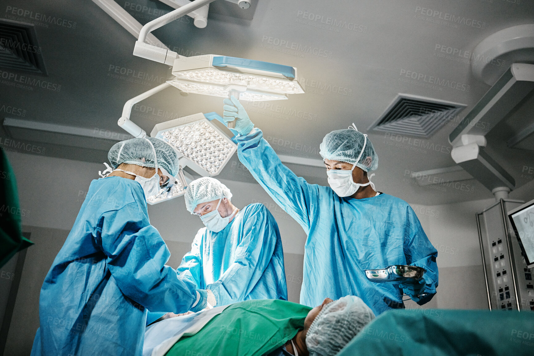 Buy stock photo Healthcare, surgery and doctors with patient in theater for emergency medical procedure. Hospital, lights and surgical team for operation on person together  in ICU, professional trust and help.