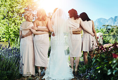Buy stock photo Rearview shot of a young bride and her bride's maids standing together outside during the day