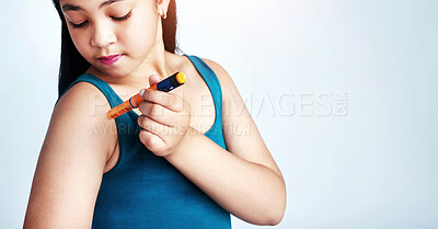 Buy stock photo Studio shot of a cute young girl injecting herself with insulin shot against a gray background