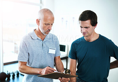 Buy stock photo Cropped shot of a handsome mature male physiotherapist having a consultation with a patient