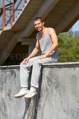 Buy stock photo A young man in sportswear sitting on a graffiti-filled wall
